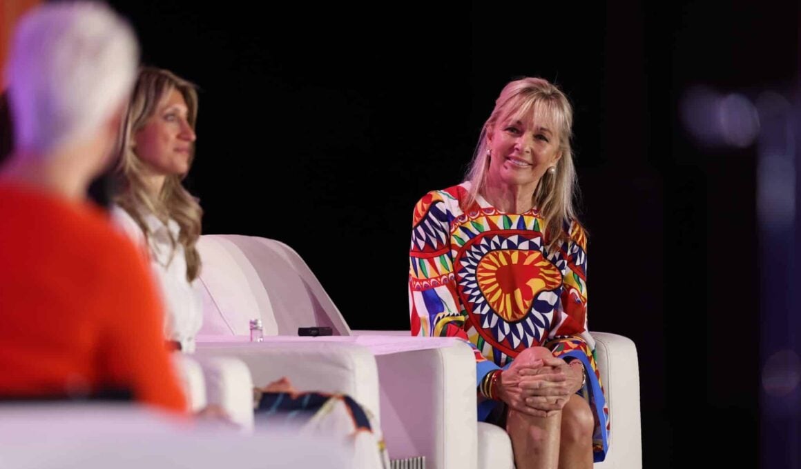 Three speakers seated in armchairs on stage at the Global Wellness Summit.